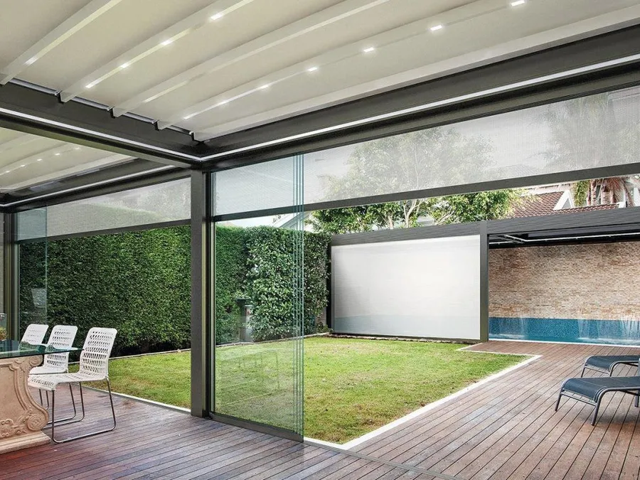 Pergola en aluminium à lames orientables installée contre la façade d’une maison